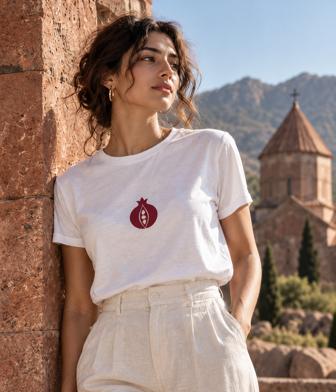 White pomegranate tee styled against sunlit pink stone